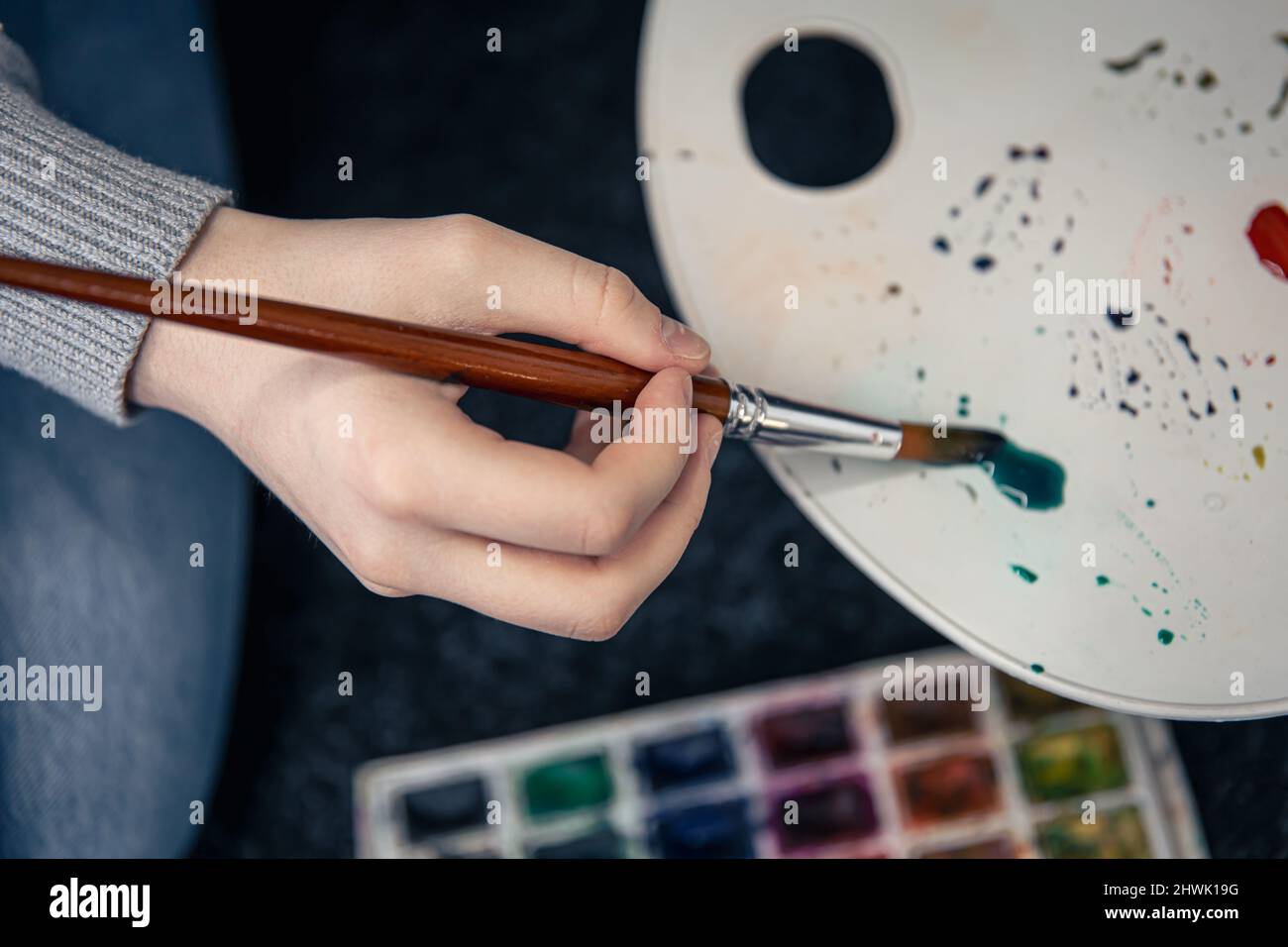 Close-up, a woman paints with a palette. Stock Photo