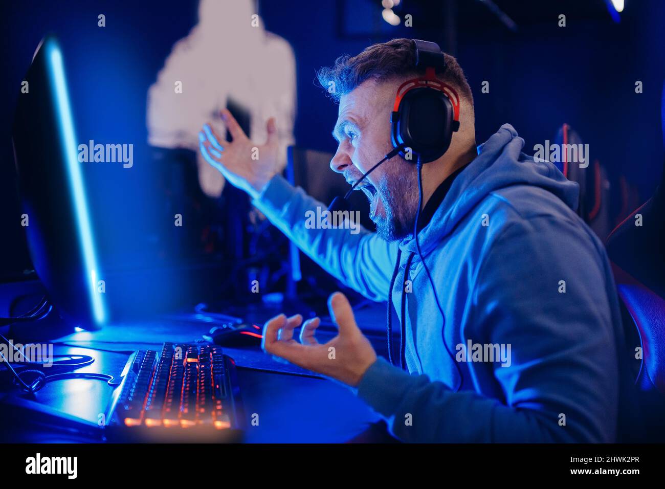 Premium Photo  Streamer man talking with multiple players into headphones  and winning video games competition. professional gamer streaming online  videogames with new graphics on powerful computer from gaming room