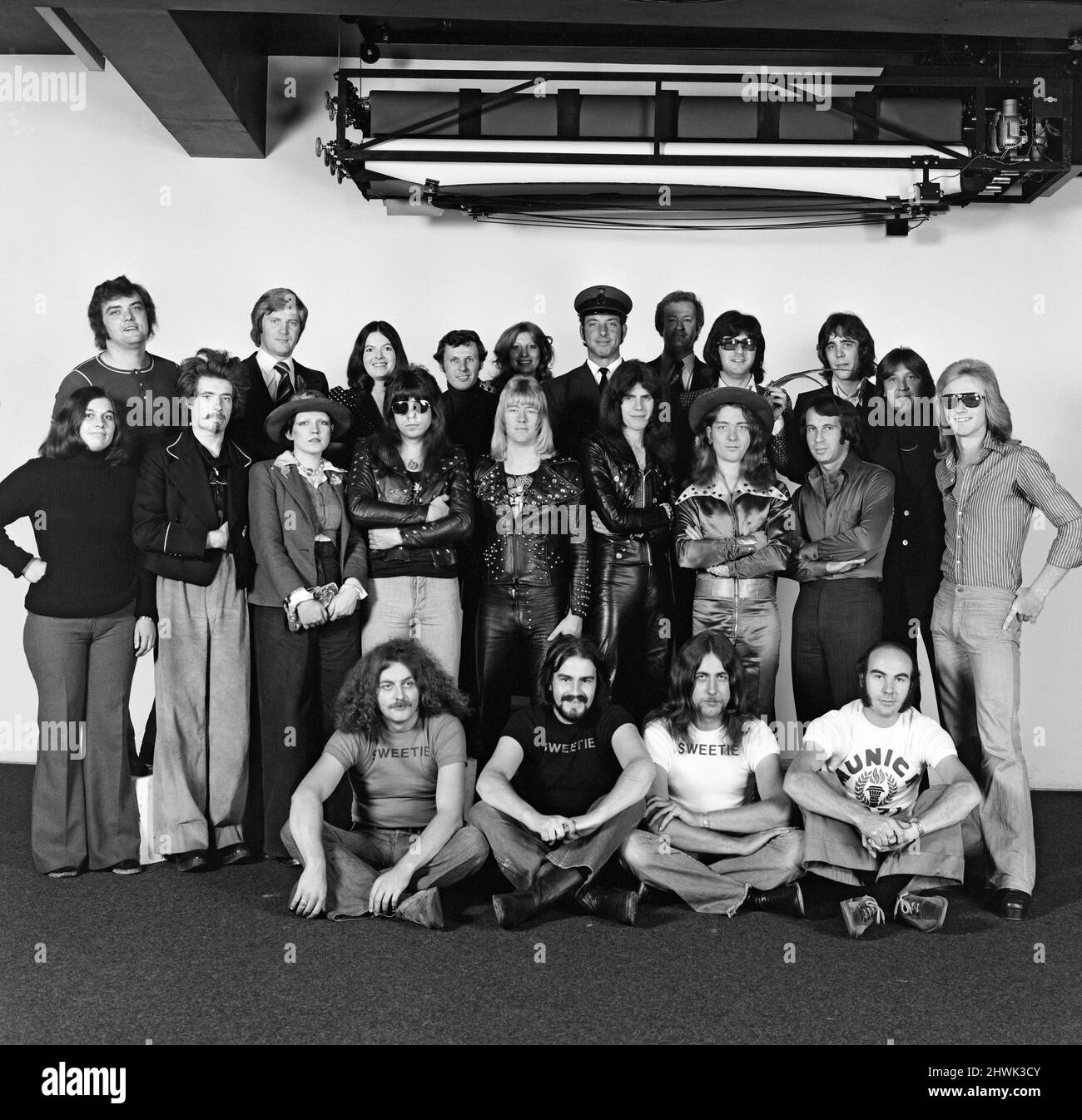 A group of people who put 'The Sweet' on the road. The four members of the band, Andy Scott, Brian Connelly, Mick Tucker and Steve Priest, are in the centre of picture. Also pictured is fan club secretary Christine Wood (back row, third from left). Front row includes roadies Terry Price, John Wayte, Ian Martin and sound mixer Jan Frewer. 8th October 1973. Stock Photo