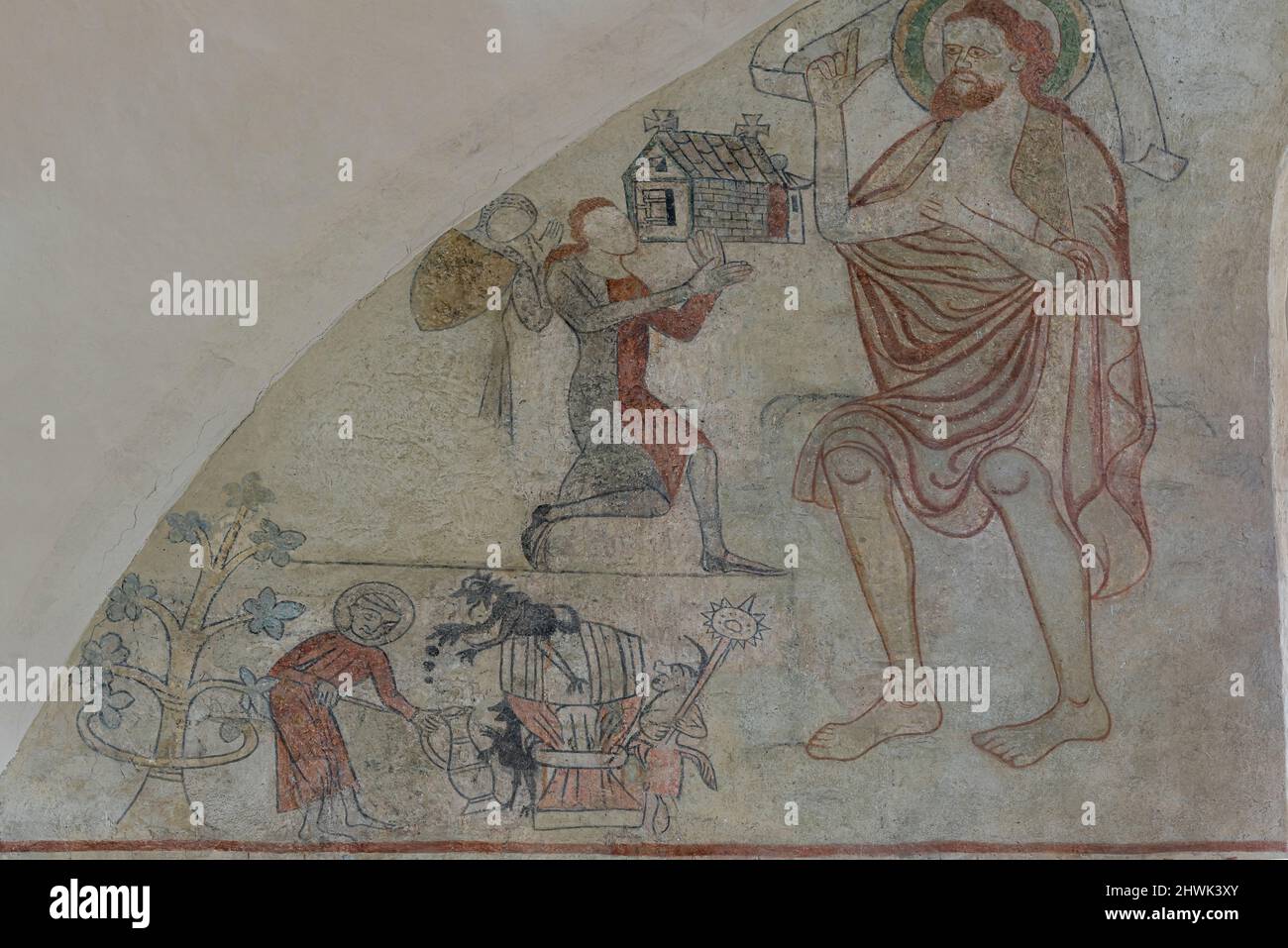 donor with a church model kneeling on front of John the Baptist, an ancient fresco on the east wall in Orslev church, Denmark, August 9, 2021 Stock Photo
