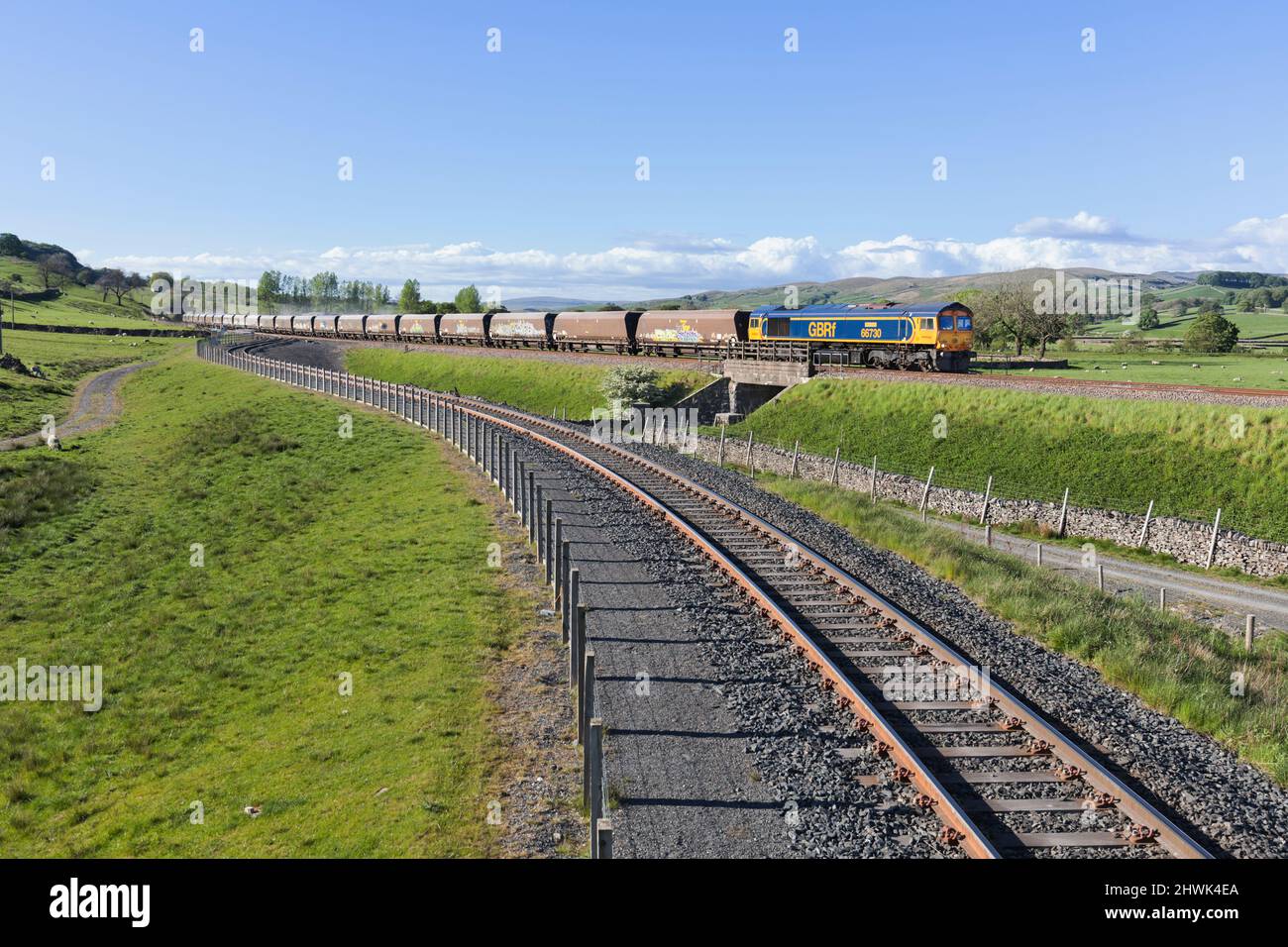 GB Railfreight class 66 locomotive 66730 passing  the siding at Arcow Quarry, Yorkshire with a train of aggregates on the Settle to Carlisle railway Stock Photo
