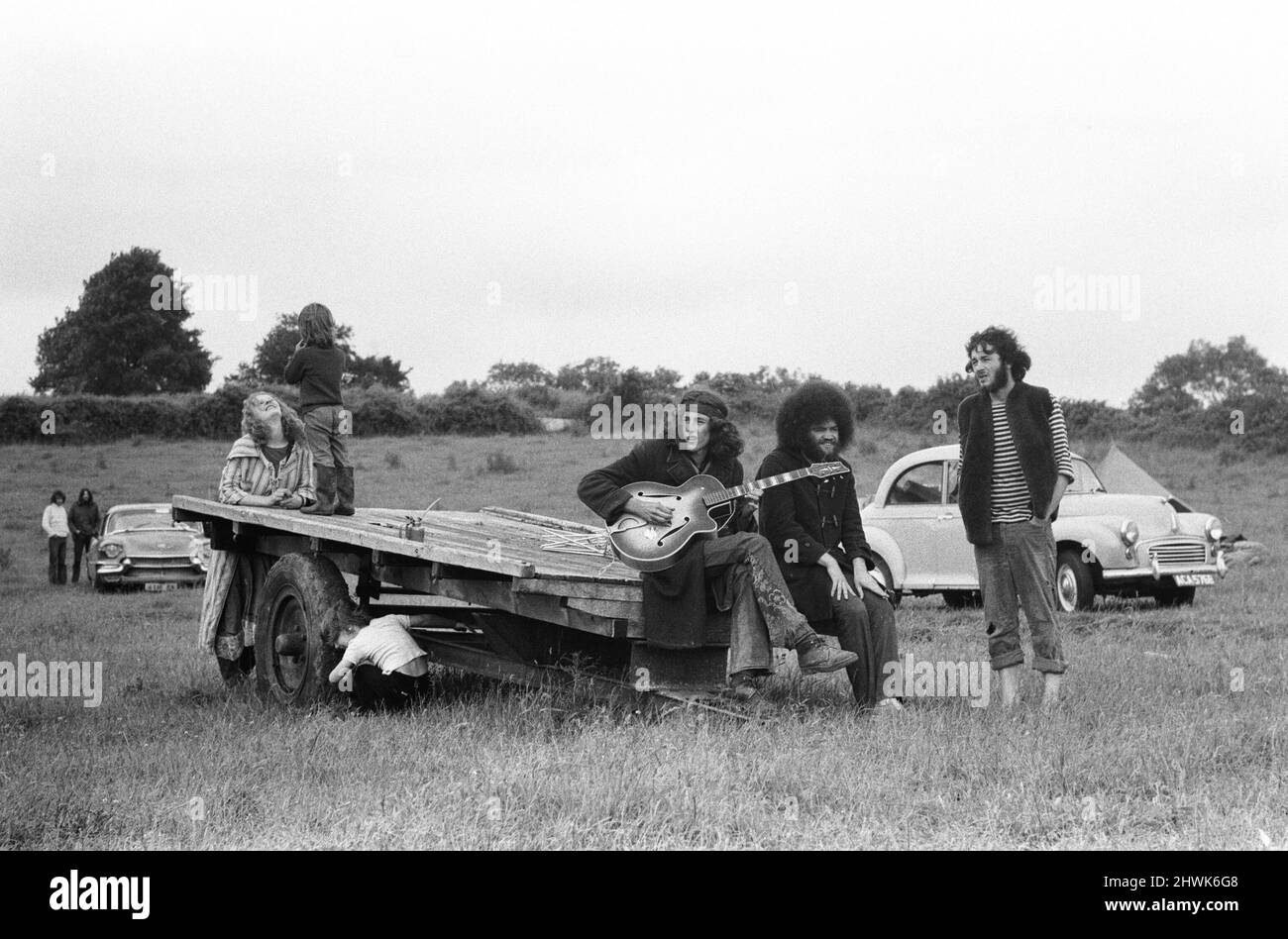 The Glastonbury Fayre of 1971, a free festival planned by Andrew Kerr and Arabella Churchill . Picture shows: Group of friends sitting on the back of a trailer playing guitar and singing songs at the festival. 19th June 1971. The Glastonbury Fayre of 1971, a free festival planned by Andrew Kerr and Arabella Churchill . Picture shows: Group of friends sitting on the back of a trailer playing guitar and singing songs at the festival. 19th June 1971.