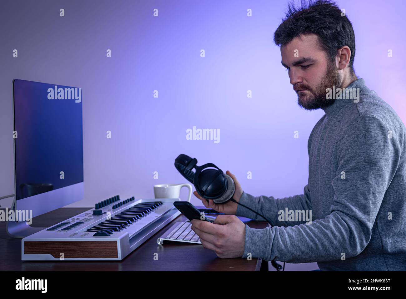 Male musician creates music using computer and keyboard, musician ...