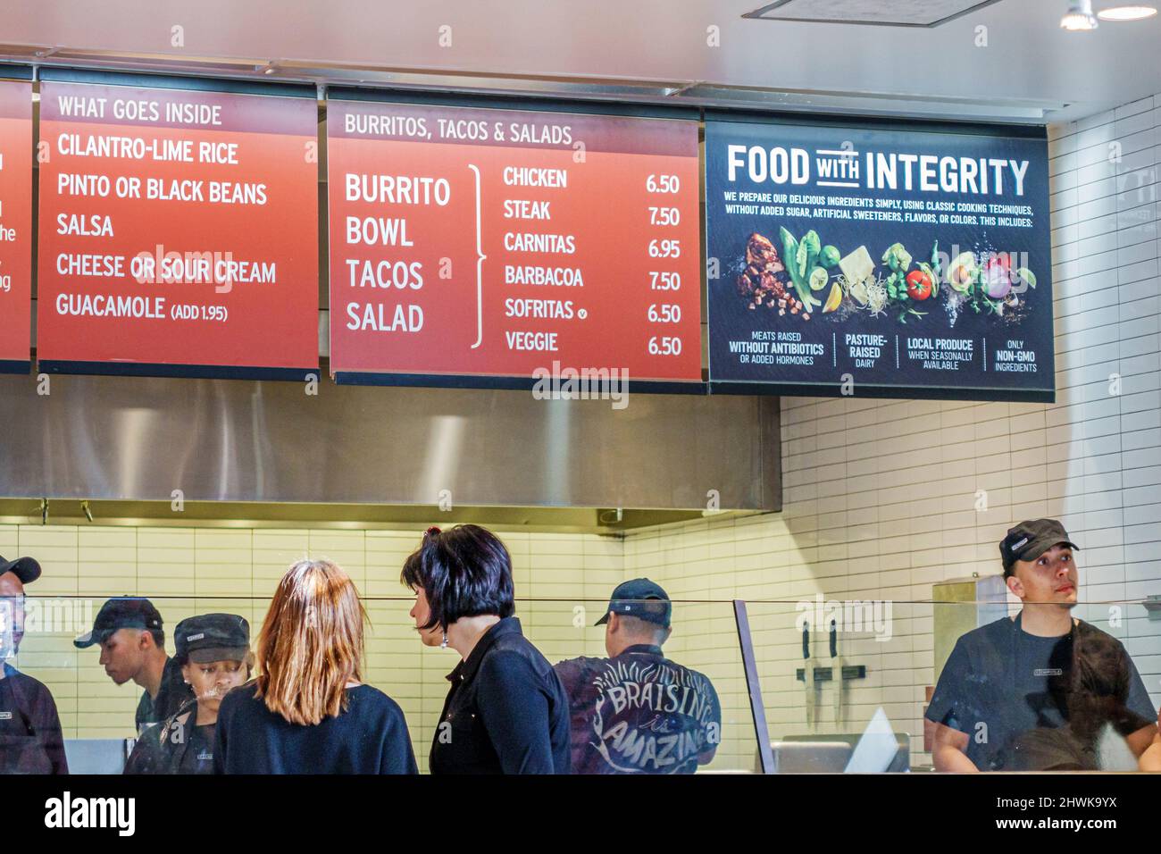 Miami Florida,Chipotle restaurant dining,Mexican interior inside line queue,overhead menu food with integrity slogan customers Stock Photo