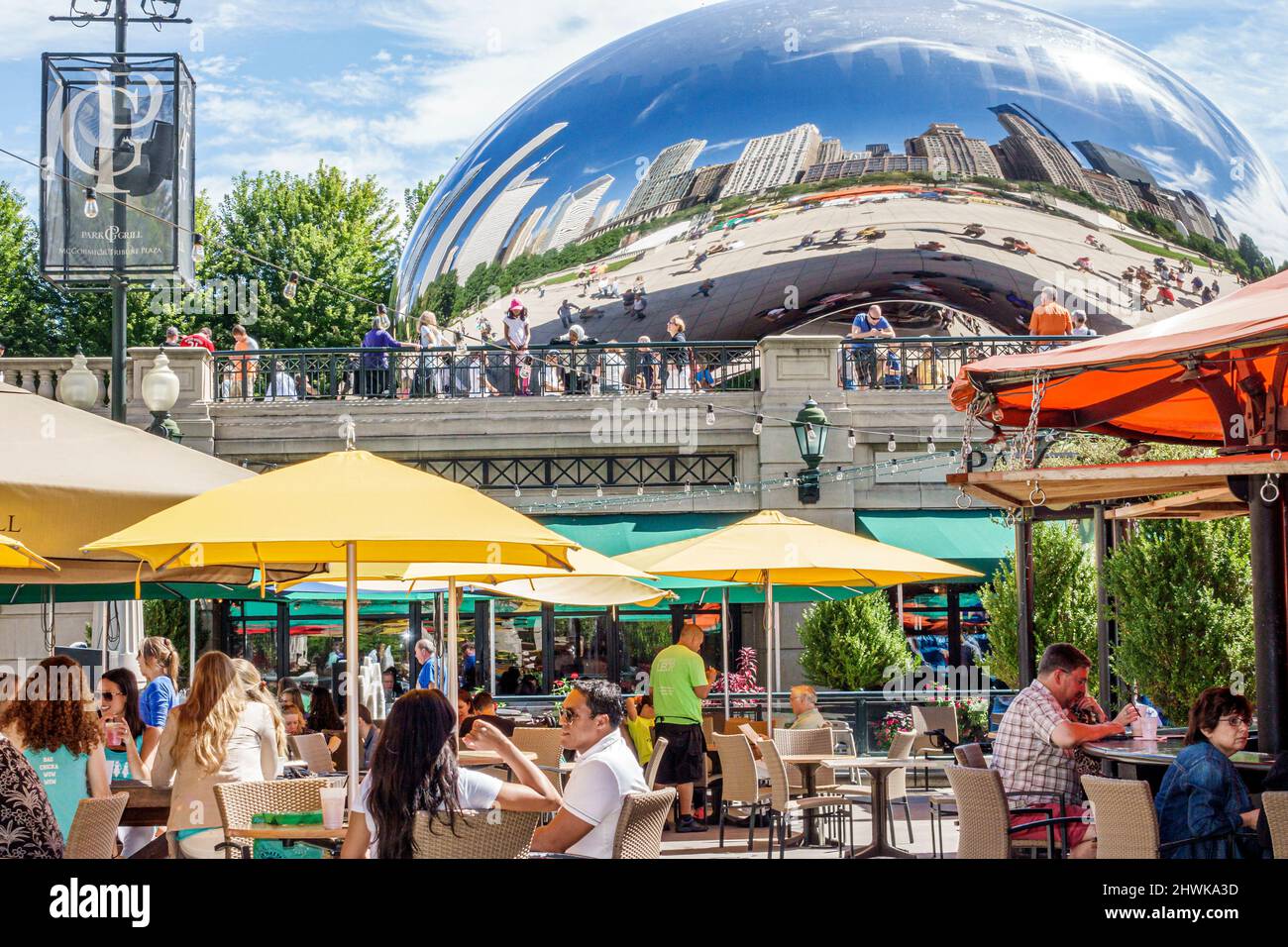 Chicago Illinois,Millennium Park,Park Grill restaurant dining al fresco umbrellas,Cloud Gate The Bean Anish Kapoor,reflection distorted city skyline Stock Photo