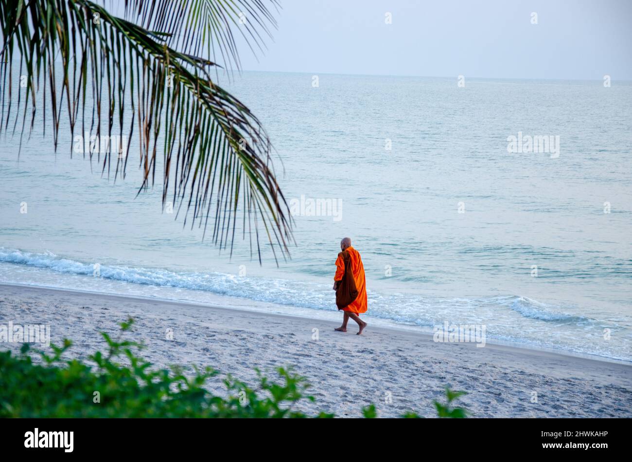 Silhouette of monk walk by the sea on a beach in Huahin , Thailand Stock Photo