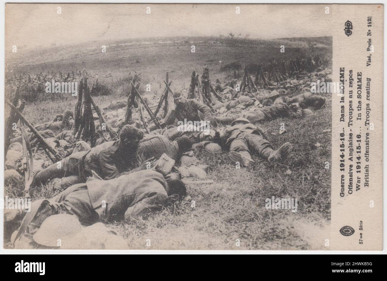 'War 1914-15-16... In the Somme. British offensive - Troops resting' / 'Guerre 1914-15-16... Dans la Somme. Offensive Anglaise - Troupes au repos'. French First World War postcard showing exhausted British soldiers on the Somme battlefield, with propped up rifles and tin helmets laid on the ground. Plumes of earth thrown up by shells can be seen on the horizon Stock Photo