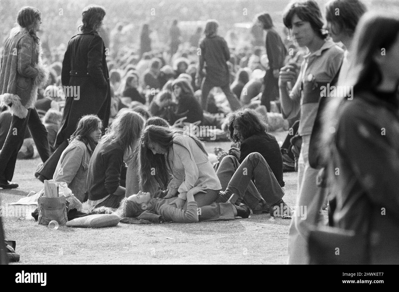 A loving couple, in their own world, just part of the huge crowd and audience enjoying The Oval Pop Festival, Oval Cricket Ground, South London, in the late summer of 1972 On the day, Rod Stewart won Best Male Vocalist 1972, Emerson Lake and Palmer won 7 awards, Maggie Bell and Brian Eno won awards too.  Note in this picture, the man on the left in the sheepskin coat. Classic fashion from the 1970s.  The festival was sponsored by Music Magazine Melody Maker  Picture taken 30th September 1972 Stock Photo