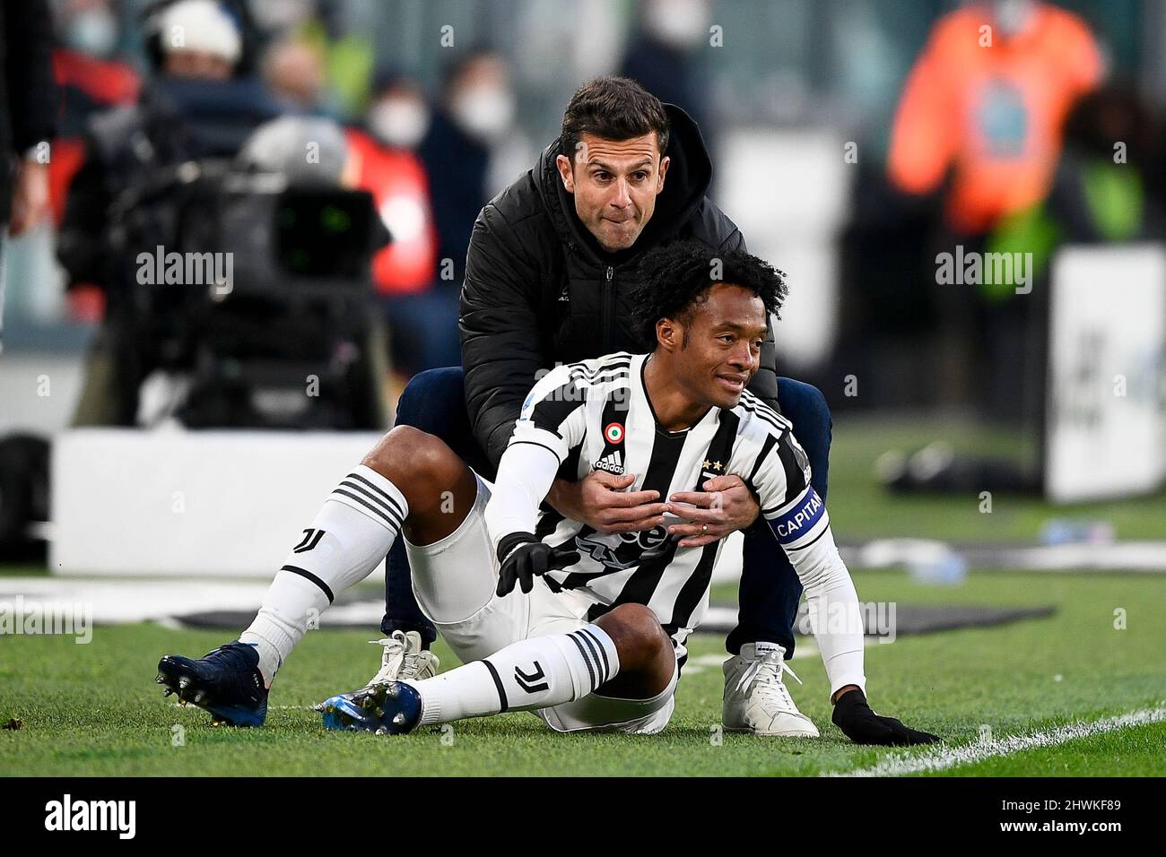Turin, Italy. 06 March 2022. Thiago Motta, head coach of Spezia Calcio,  helps Juan Cuadrado of Juventus FC to stand up during the Serie A football  match between Juventus FC and Spezia