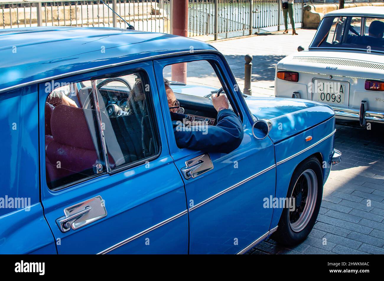 Old man with his arm out of a classic car. Blue Renault 8. Stock Photo