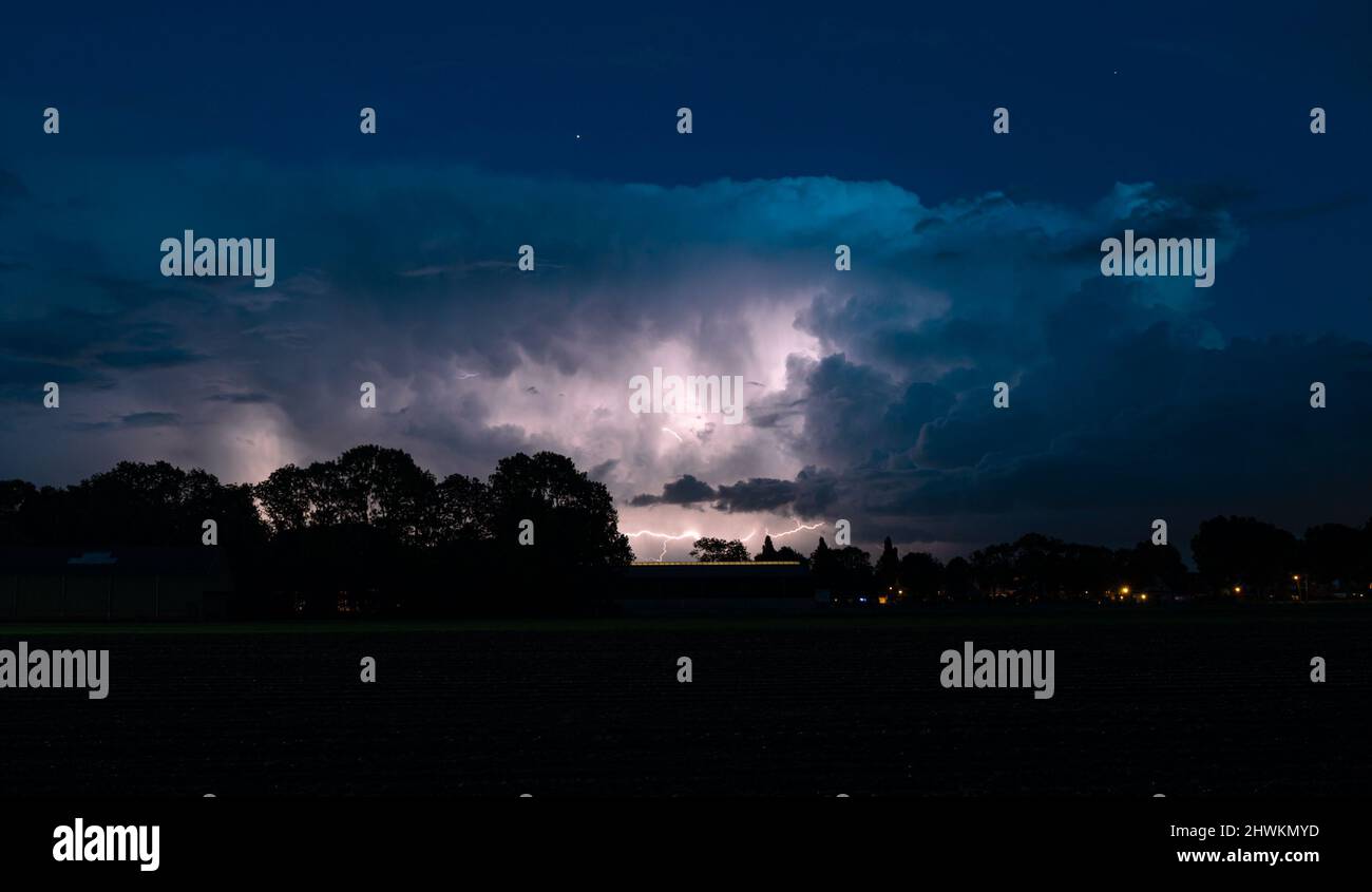 Panoramic view of a storm cloud illuminated by lightning flashes Stock