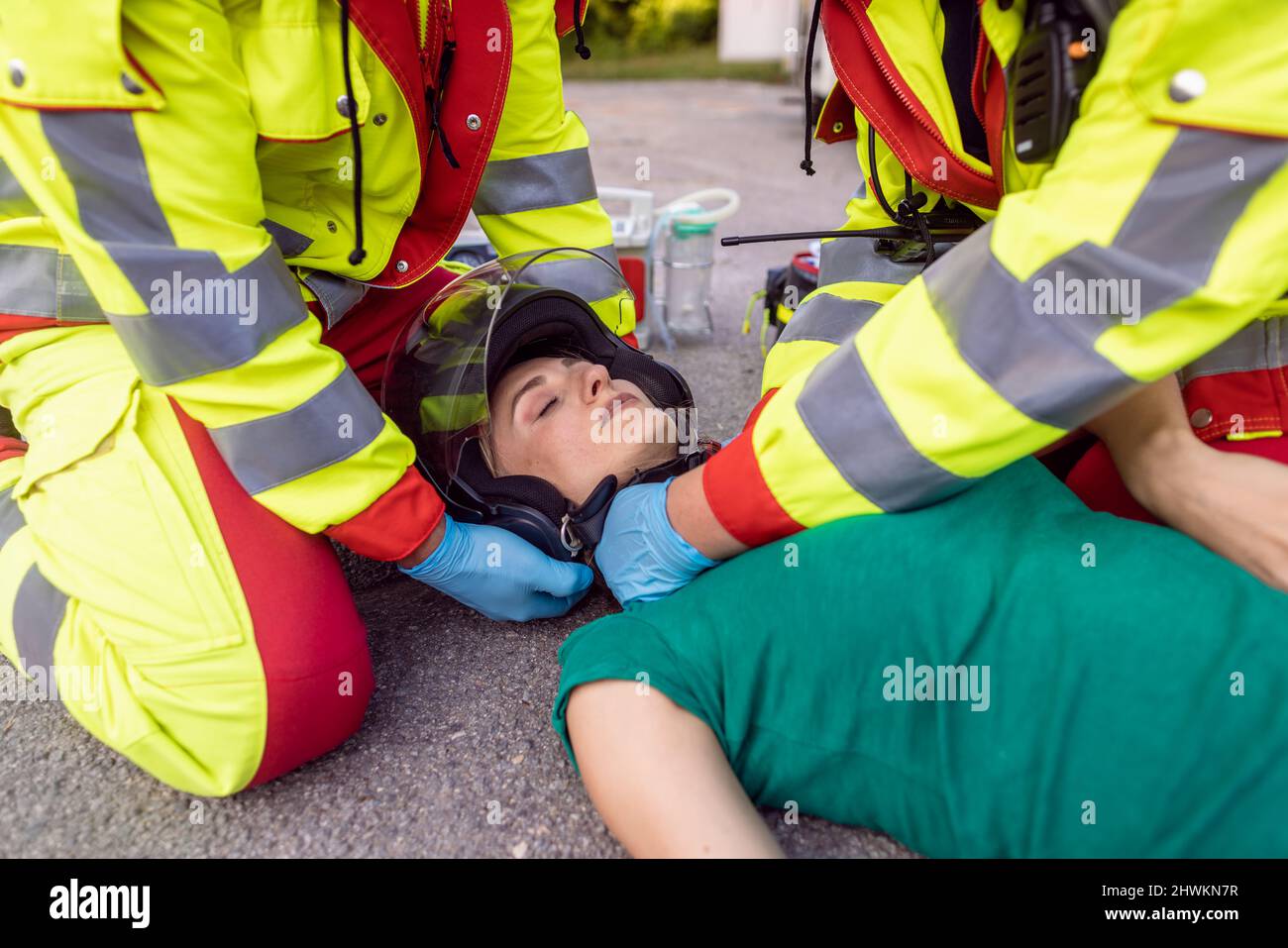 Paramedics removing helmet of injured motorcyclist after an accident