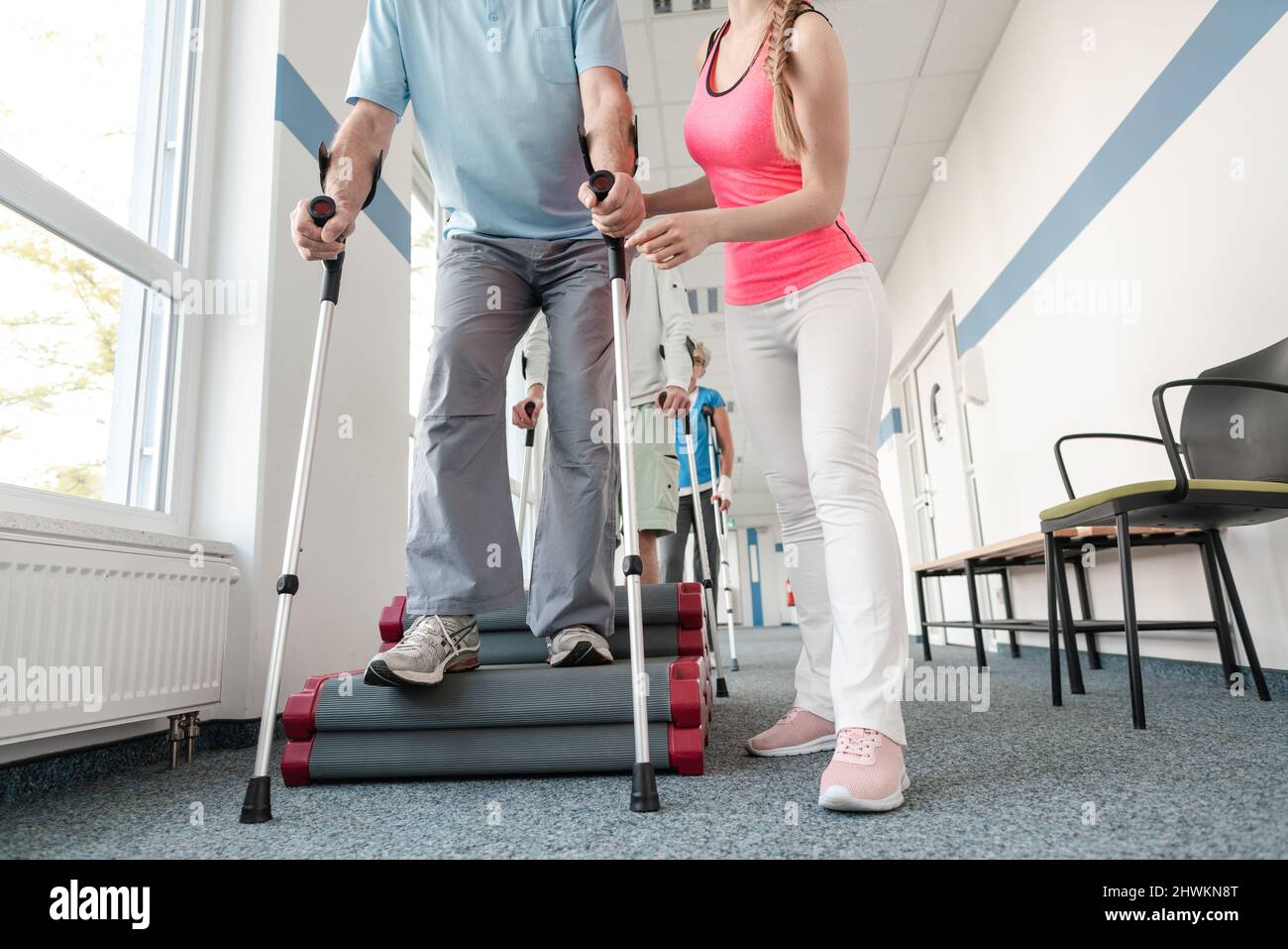 Seniors In Rehabilitation Learning How To Walk With Crutches Stock Seniors in rehabilitation learning how to walk with crutches stock