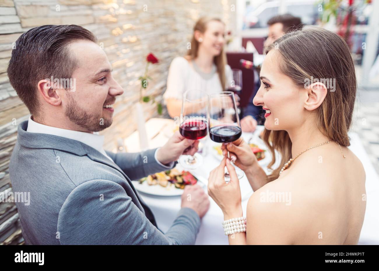 Men and women having a good time with food and drink in restaurant Stock Photo