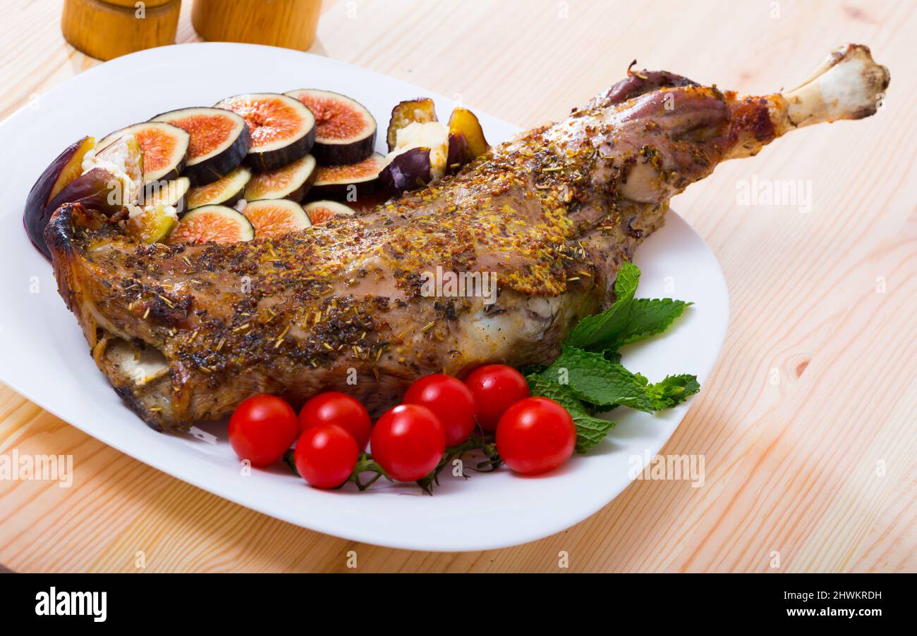 Tasty shoulder of lamb baked in oven with honey, served with fig, feta