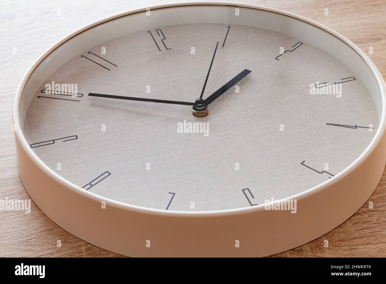 Close-up of a large round clock hand marking ten to two o'clock. Stock Photo