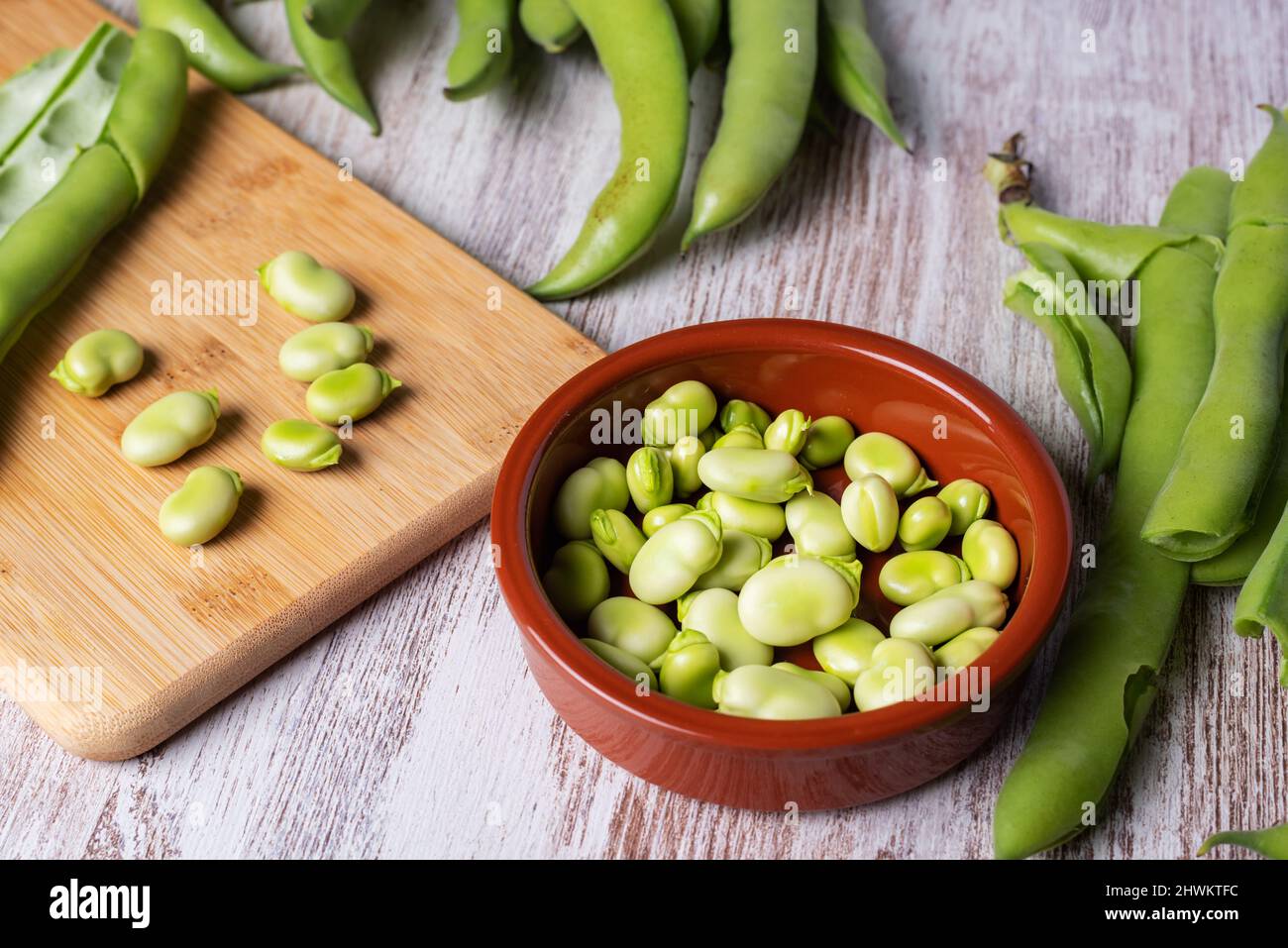 Fresh broad beans next to a clay plate with its fruit Stock Photo Alamy