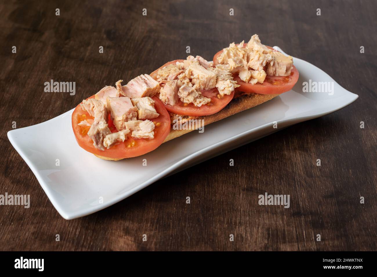 Toasted bread with sliced tomato and bonito tuna. Stock Photo