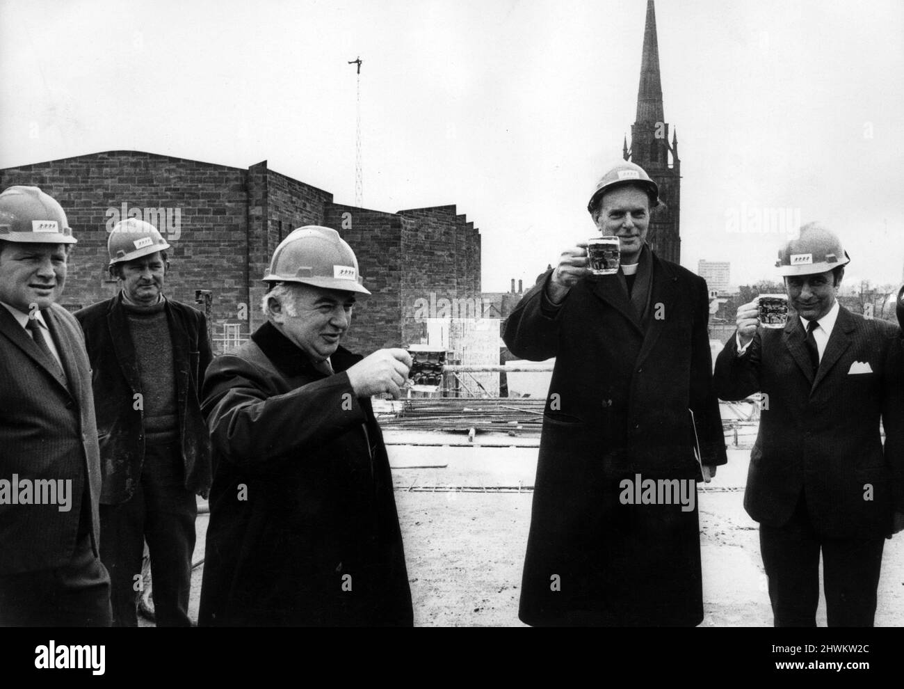 The traditional toast at the end of the topping-out ceremony at the ¿2 million De Vere Hotel, adjoining Coventry Cathedral. The final layer of concrete on the hotel roof was levelled by Mr. Leslie Jackson (centre) deputy chairman of De Vere Hotels and Restaurants Ltd, who invited the Deputy Mayor of Coventry, Alderman Ralph Clews, and the Provst of Coventry Cathedral, Dr. H.C. N Williams (second from right) to help him make the finishing touches. 11th April 1972. Stock Photo