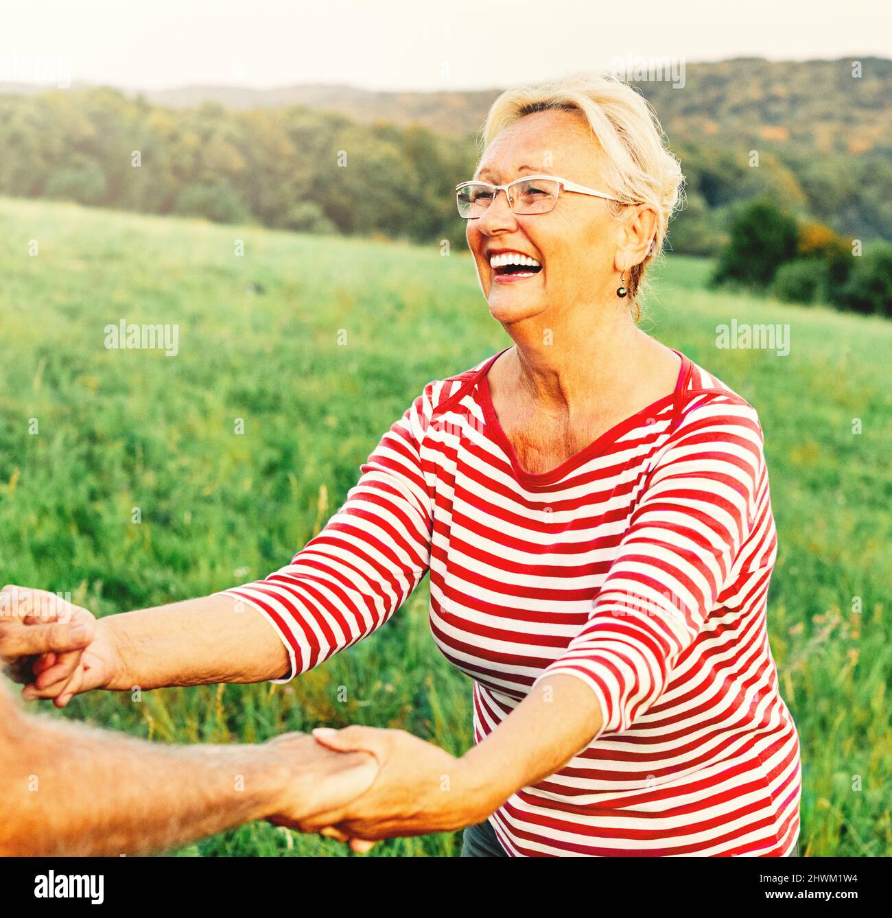woman man outdoor senior couple happy lifestyle retirement together smiling love dancing fun playing game active vitality nature mature Stock Photo