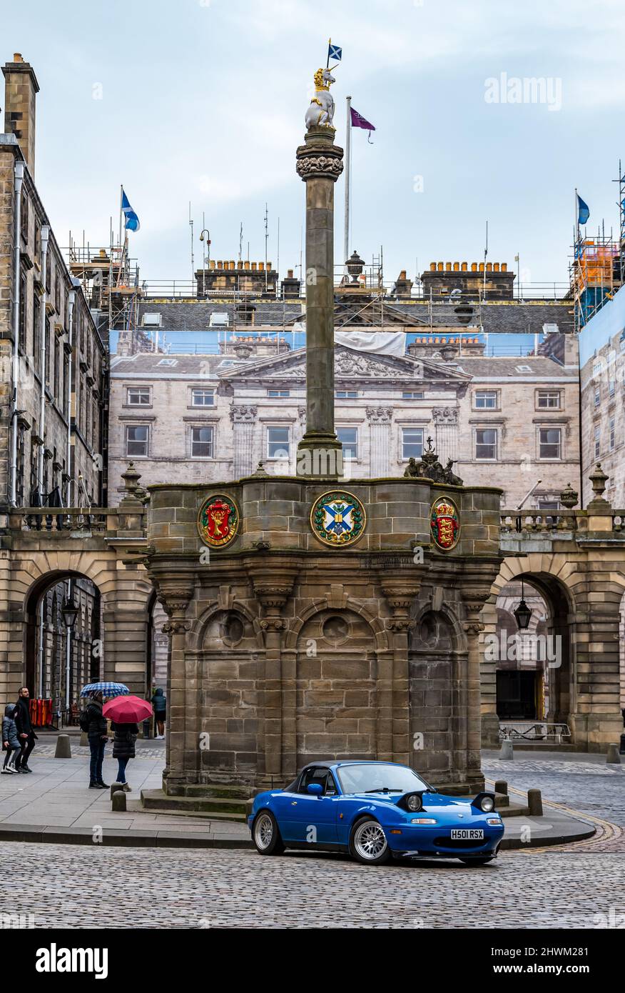 Mazda sports car parked by mercat or market cross with unicorn, Royal Mile, Edinburgh, Scotland, UK Stock Photo