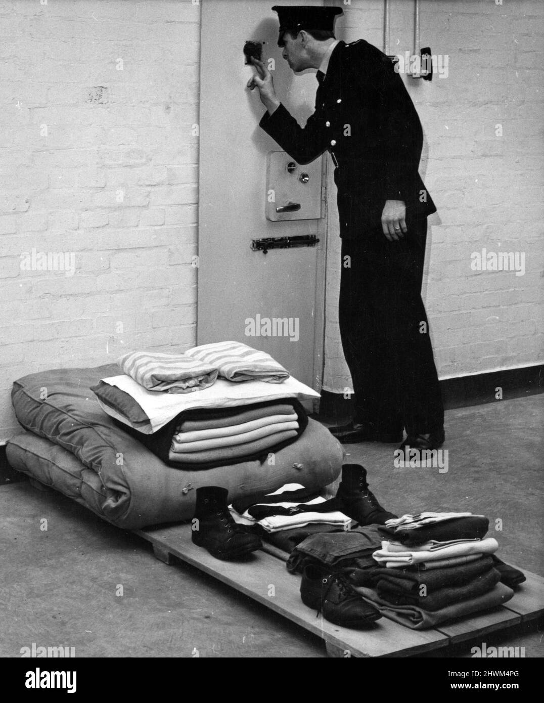 In the special punishment block at Hindley Borstal, Greater Manchester,  a prison officer checks through the observation window. 10th July 1973. Stock Photo