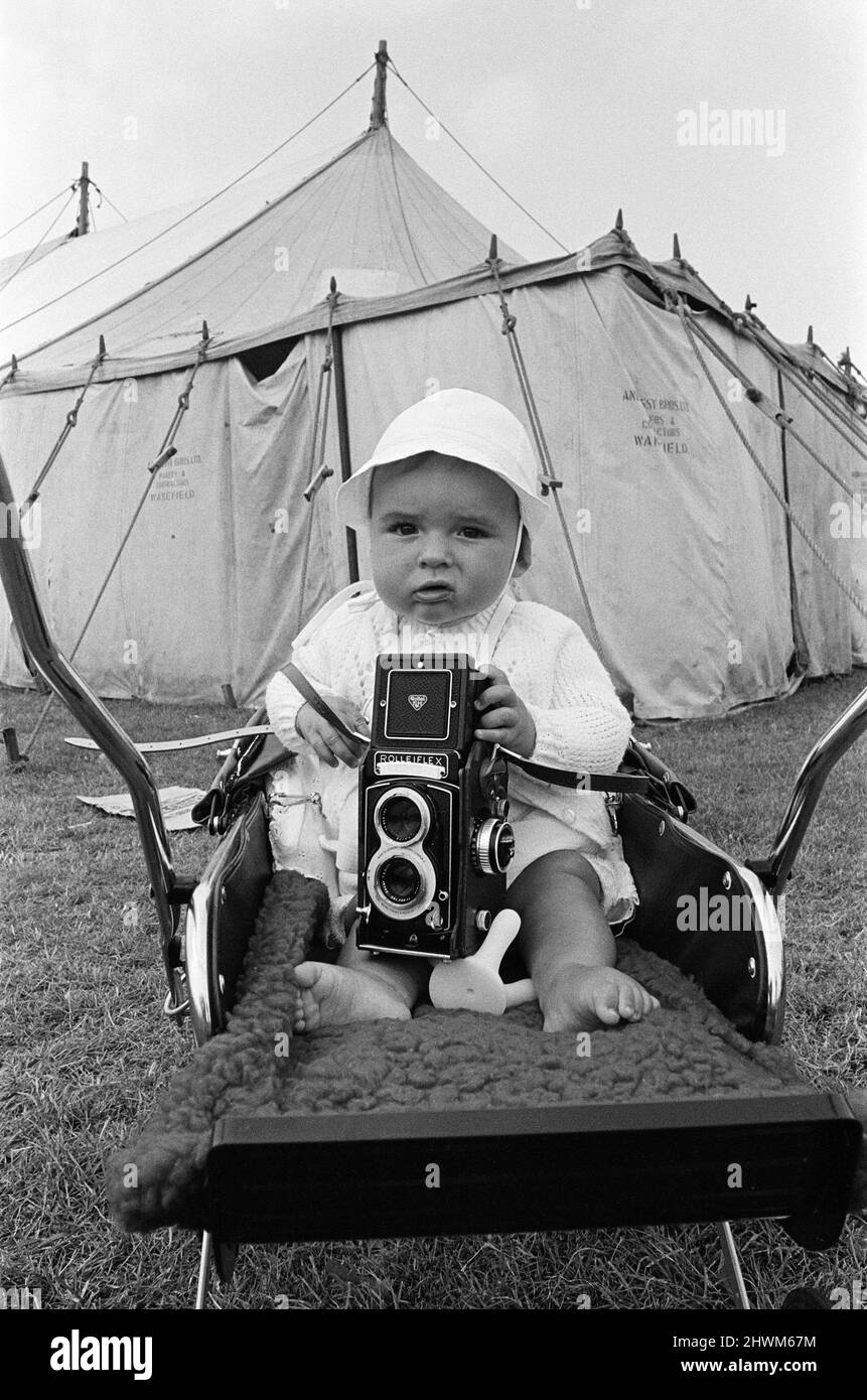 A baby sitting with a Rolleiflex camera at Skelton annual baby show. Circa 1973. Stock Photo