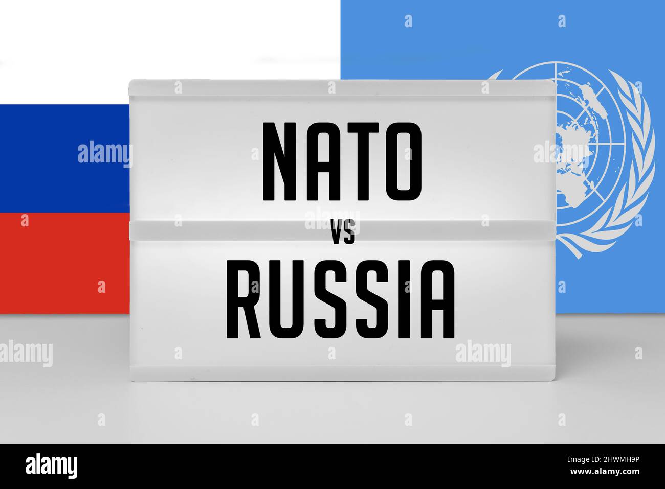 Nato vs Russia text with flags in the background Stock Photo