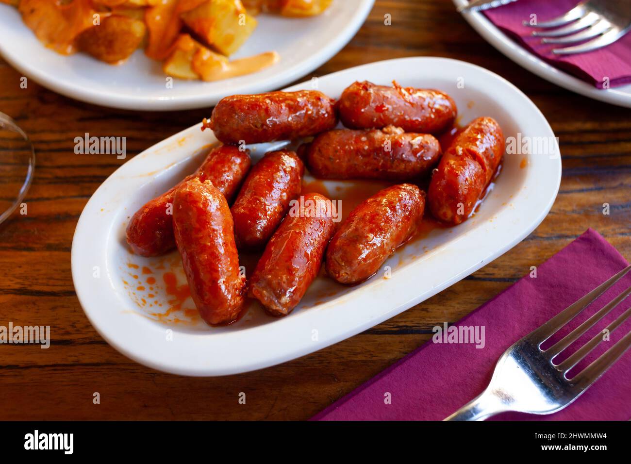 Spanish mini chorizo sausages at plate on table Stock Photo Alamy