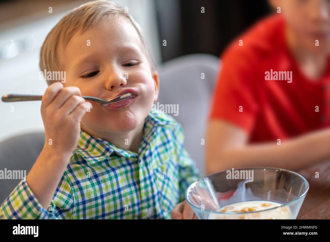 Cute sleepy child eating his oatmeal out of a bowl Stock Photo Alamy