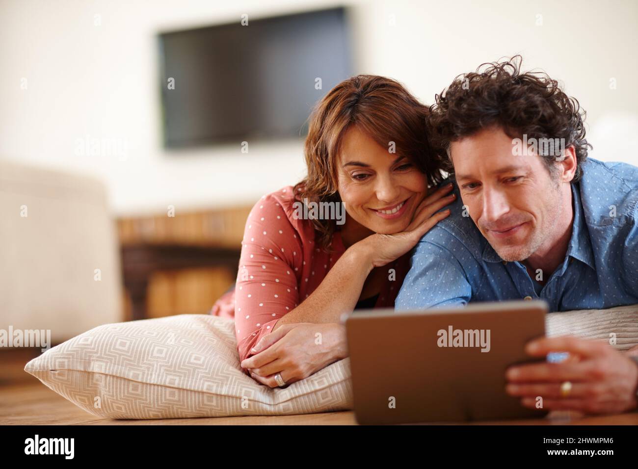 Time to unwind online. Shot of a husband and wife using a digital tablet together at home. Stock Photo