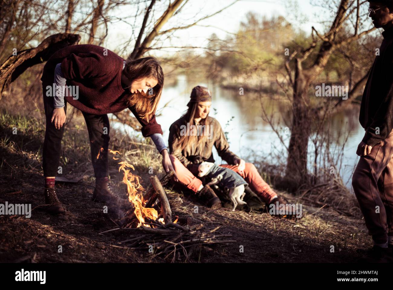 Young strong alternative friends make a fire riverside Stock Photo
