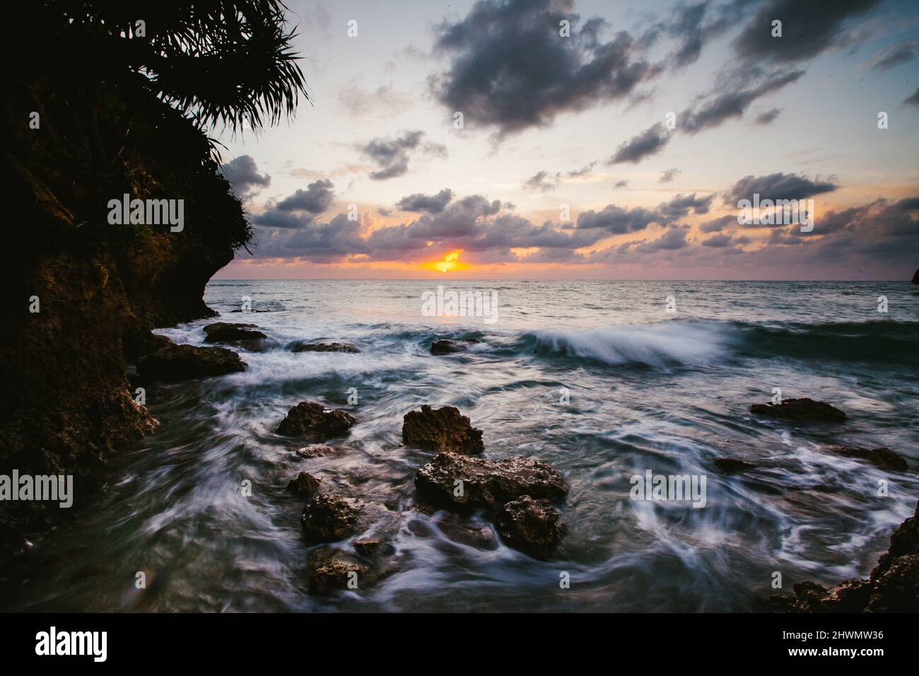 Ocean waves landscape with sunset and rocks Stock Photo