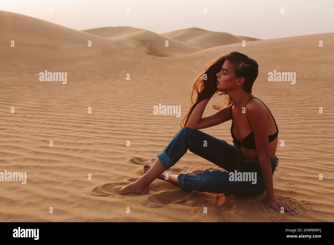 Girl posing in the sand in the desert Stock Photo - Alamy