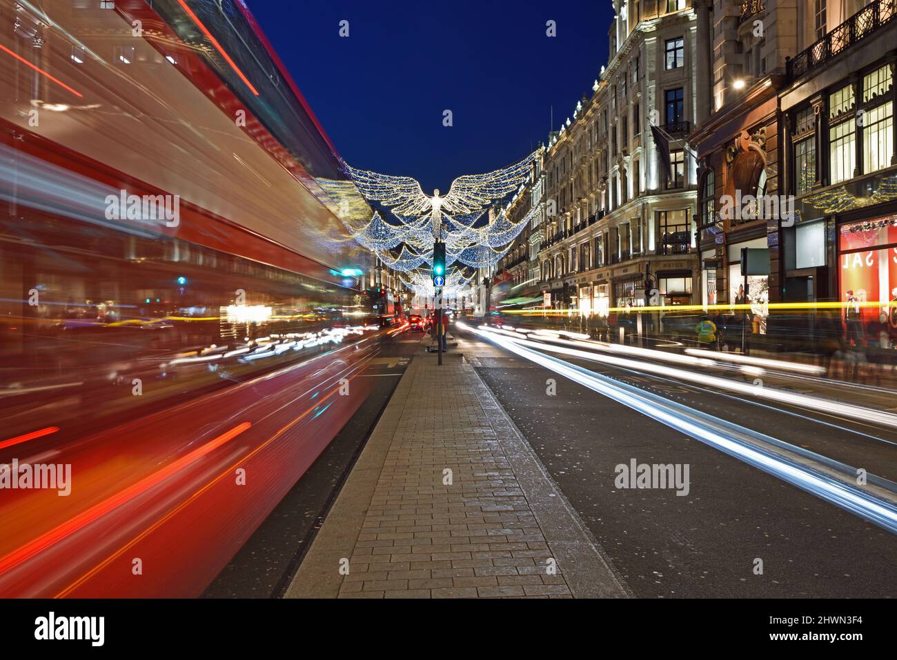 Red bus travelling down Regents Street towards Oxford Street at Christmas time.  Light trails. Stock Photo