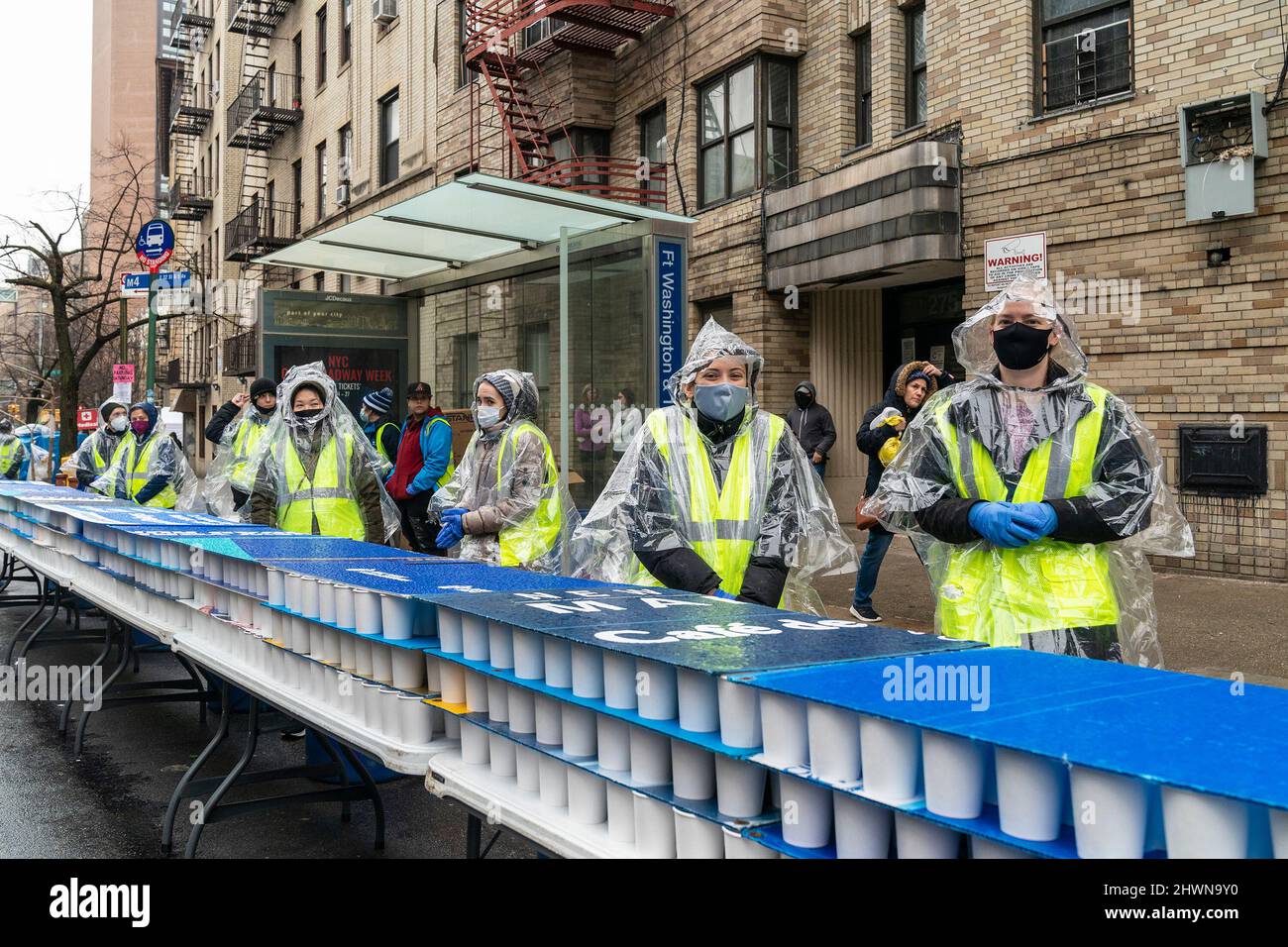 Volunteers prepare food and drinks for runners participated in NYRR Washington Heights Salsa, Blues, and Shamrocks 5K race on streets of Upper Manhattan. Some runners were celebrating St. Patrick's Day, some were wearing yellow and blue colors in support of Ukraine under aggression from Russia. Main themes of this year race was to honor two police officers Jason Rivera who was member of Dyckman Run Club and Wilbert Mora, both officers were killed in Harlem while attending domestic violence call. (Photo by Lev Radin/Pacific Press) Stock Photo