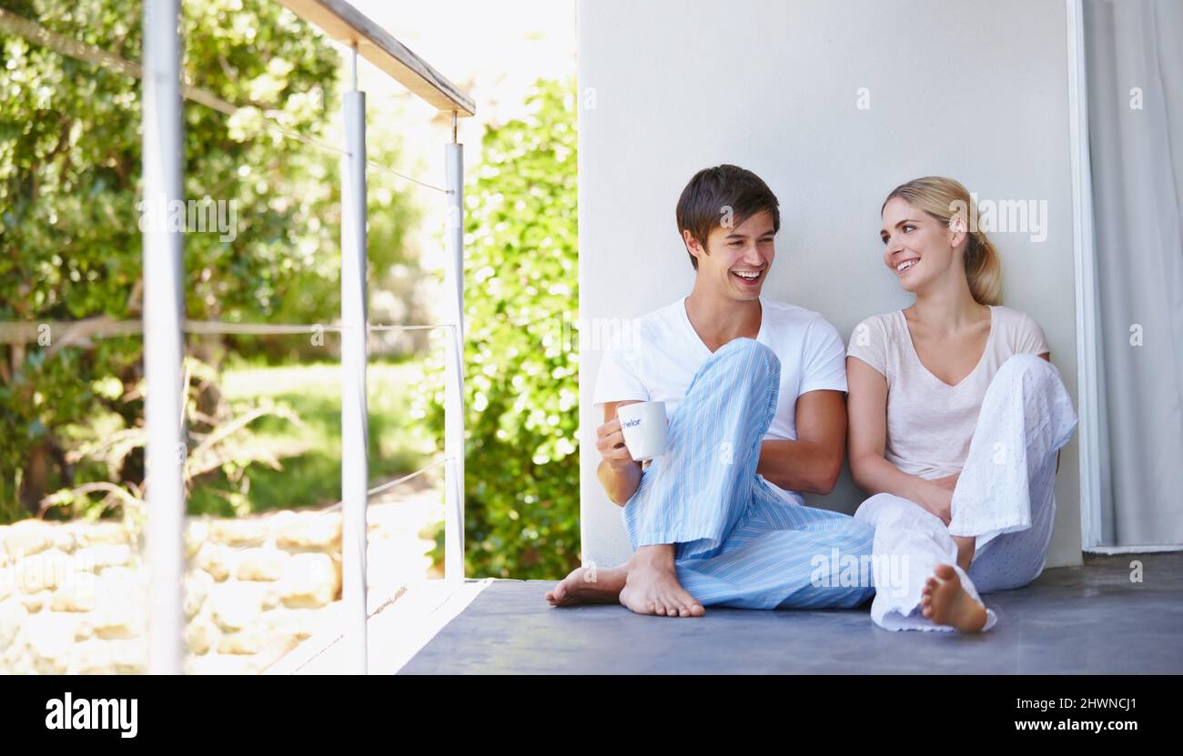 I love you more than lazy Sunday mornings. Shot of a happy young couple spending some time together on the patio in the morning. Stock Photo