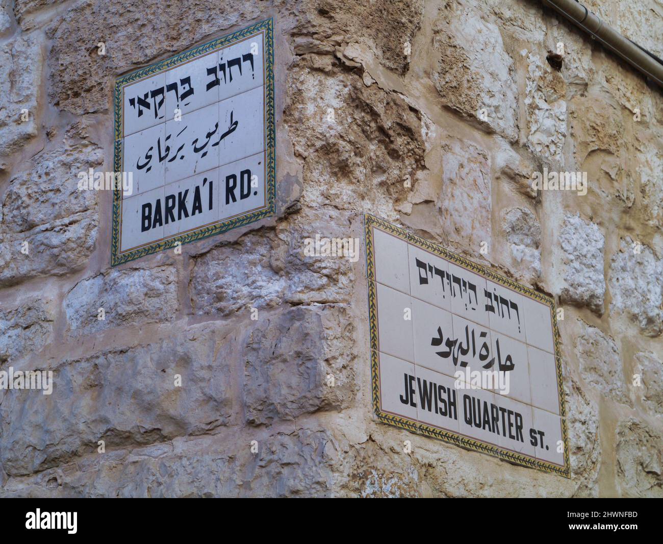 Jerusalem, ceramic tile street signs embedded in stone wall of buildings in Jewish Quarter of Old City, trilingual in Hebrew, Arabic and English Stock Photo