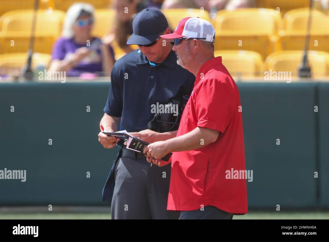 Baton Rouge, LA, USA. 6th Mar, 2022. Louisiana Tech Head Coach Josh Taylor meets with home plate umpire Brian Crochet to make a lineup change during NCAA Softball action between the Louisiana Tech Bulldogs and the LSU Tigers at Tiger Park in Baton Rouge, LA. Jonathan Mailhes/CSM/Alamy Live News Stock Photo