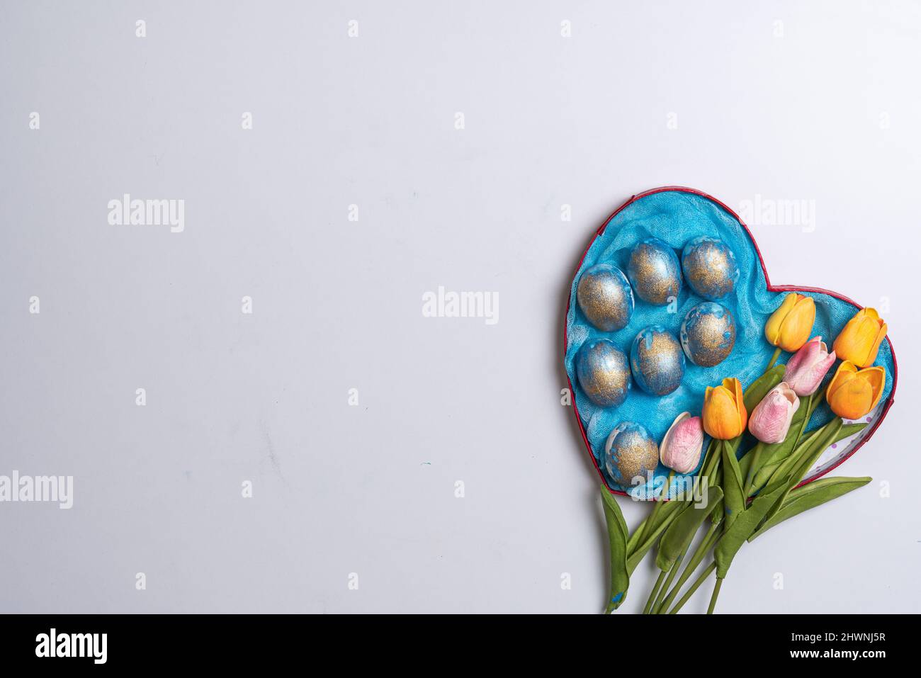 Happy easter time. Bright Easter holiday concept with spring flowers and easter eggs. Colorful Easter eggs background Stock Photo