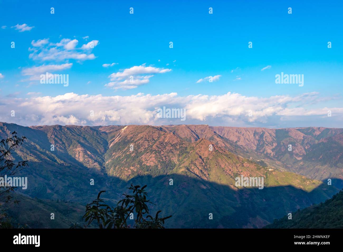 mountain range covered with bright blue sky at afternoon from different angle image is taken at shillong meghalaya india. Stock Photo