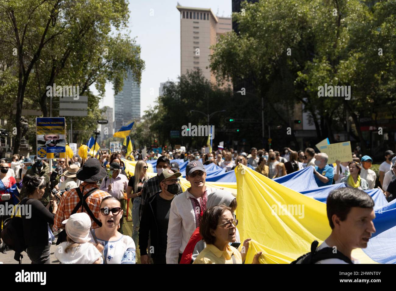 Anti-war protests in Mexico City Ukrainian supporters demonstration in Reforma Street. Flags, indignation and large group of people walking. Stock Photo