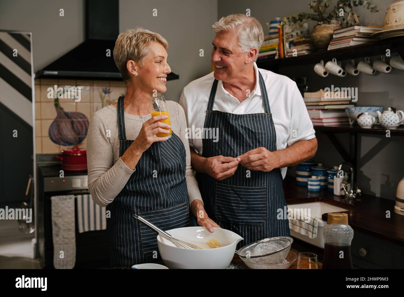caucasian smiling elderly couple cooking in kitchen Stock Photo