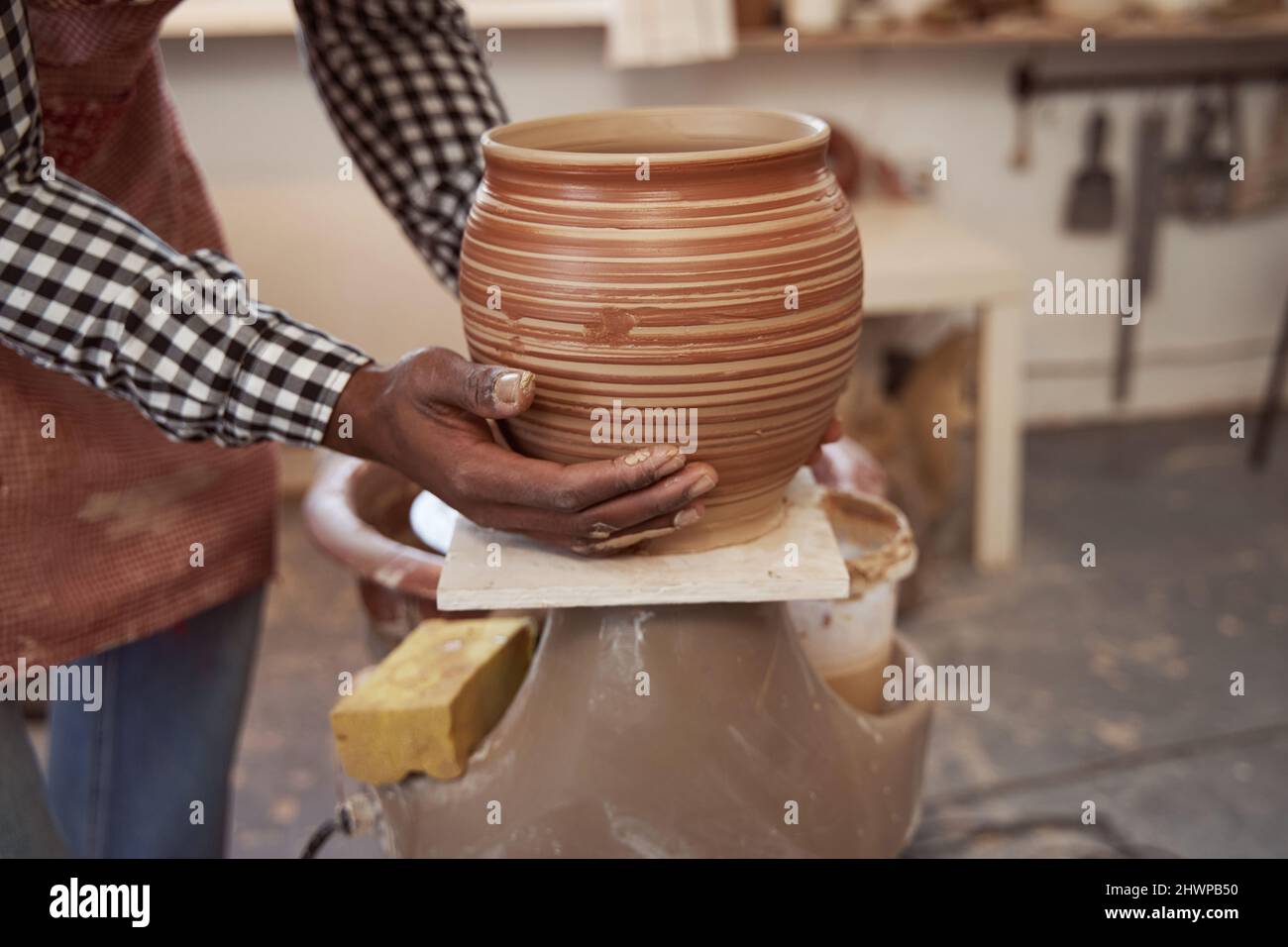 Skilled artisan preparing earthenware vessel for drying Stock Photo