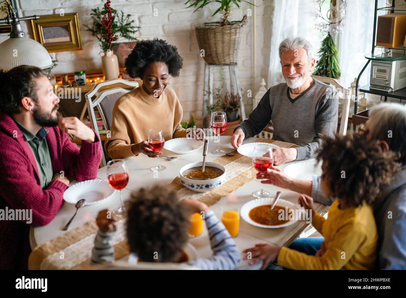 Happy multiethnic multigeneration family having fun together around kitchen table. Stock Photo