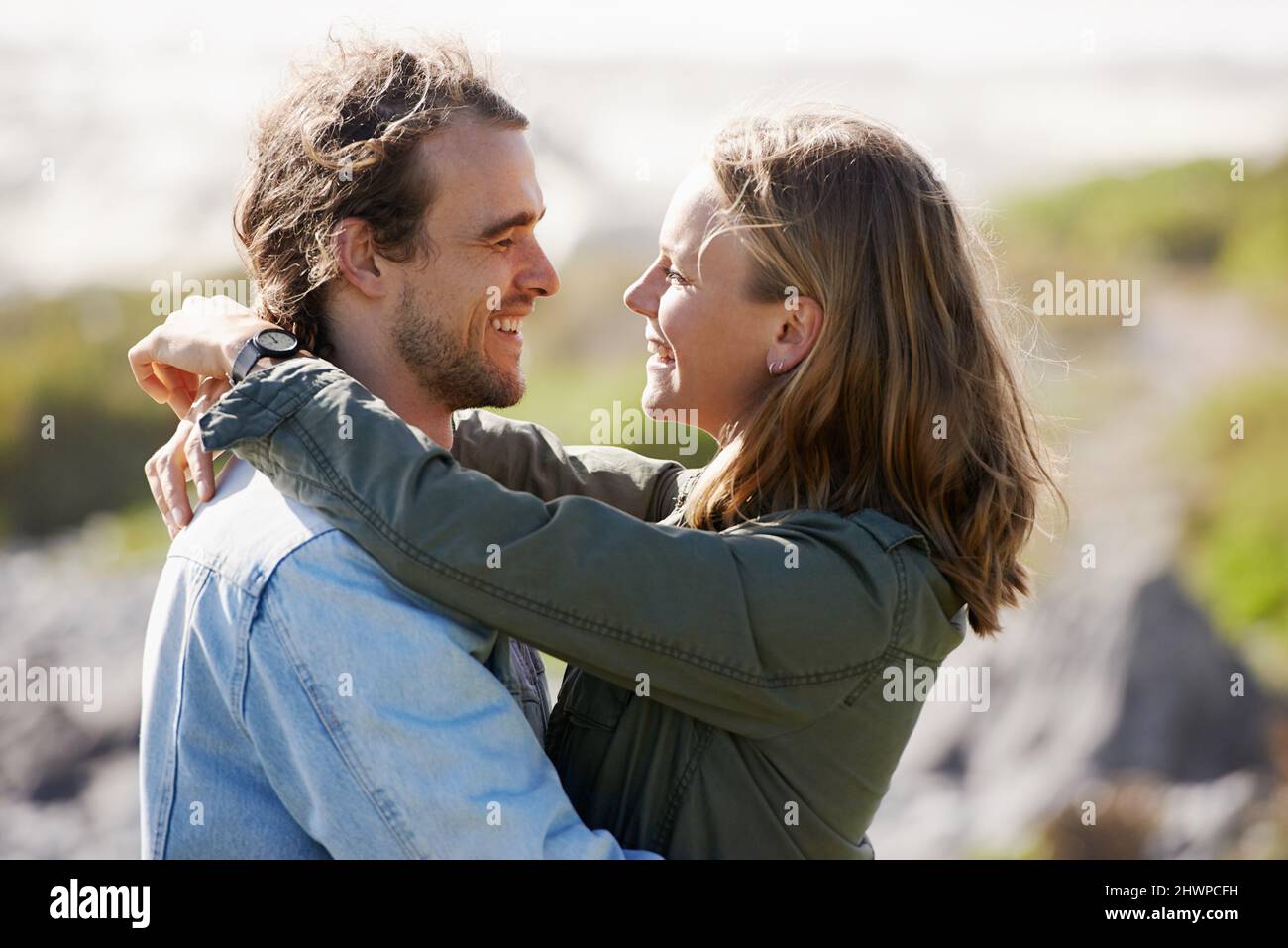 Just loving their romantic getaway. Shot of an affectionate young couple standing face to face in the outdoors. Stock Photo