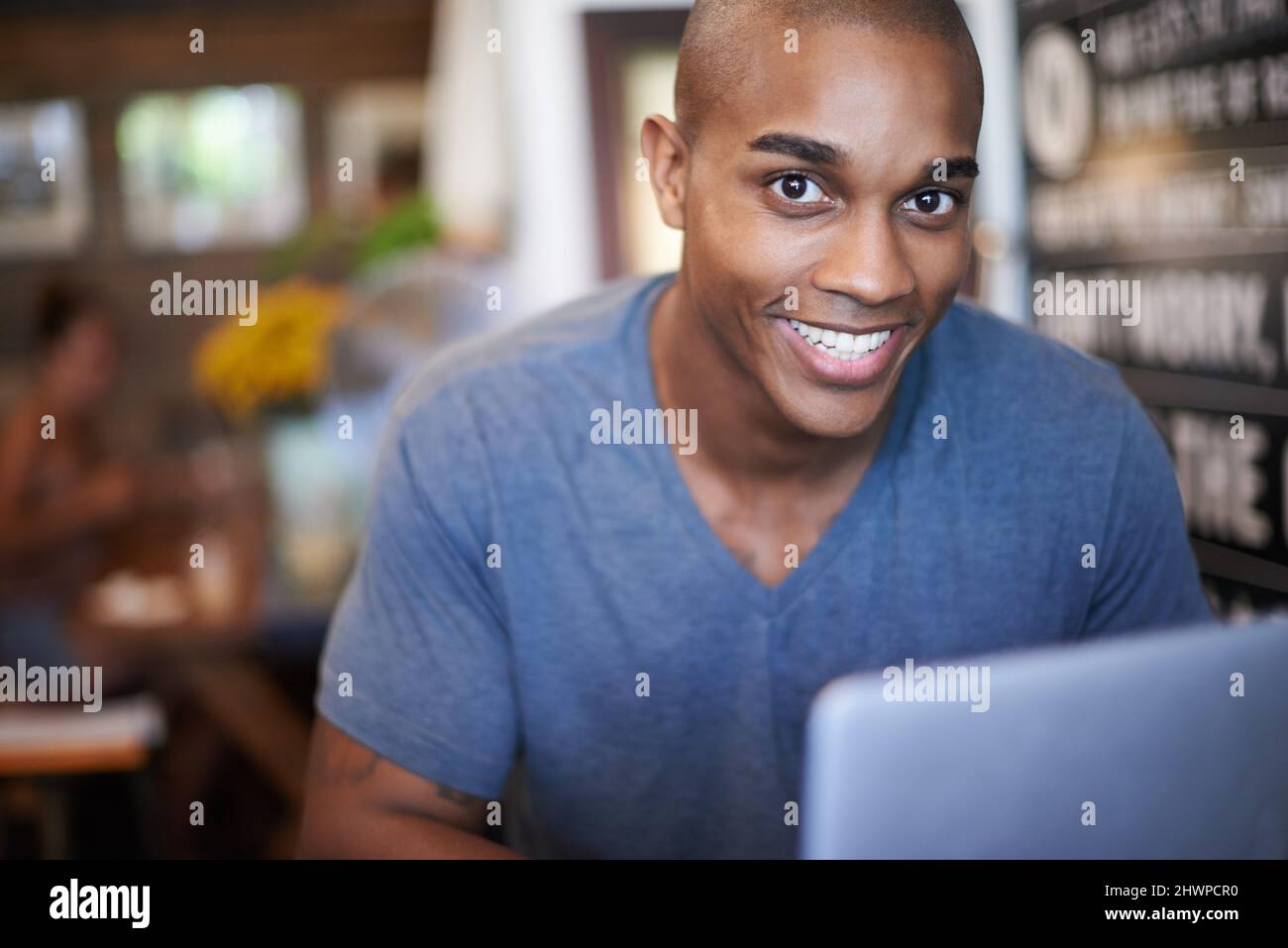 This cafe has free wifi. Cropped shot of a handsome young man using his laptop in a coffee shop. Stock Photo