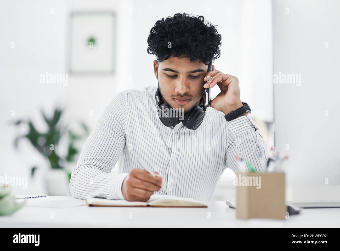 Can you repeat that please. Shot of a young businessman writing notes ...