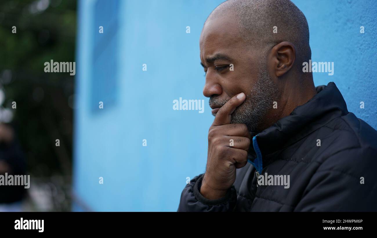 A preoccupied senior man thinking deeply outside in street an african ...