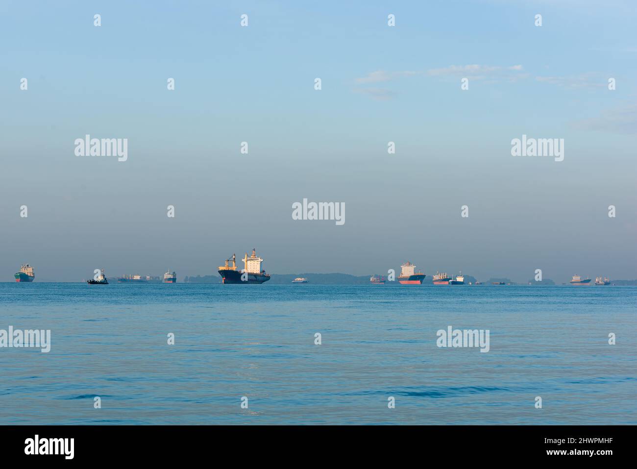 Cargo ships, oil tankers and bulk carriers moored offshore along the
